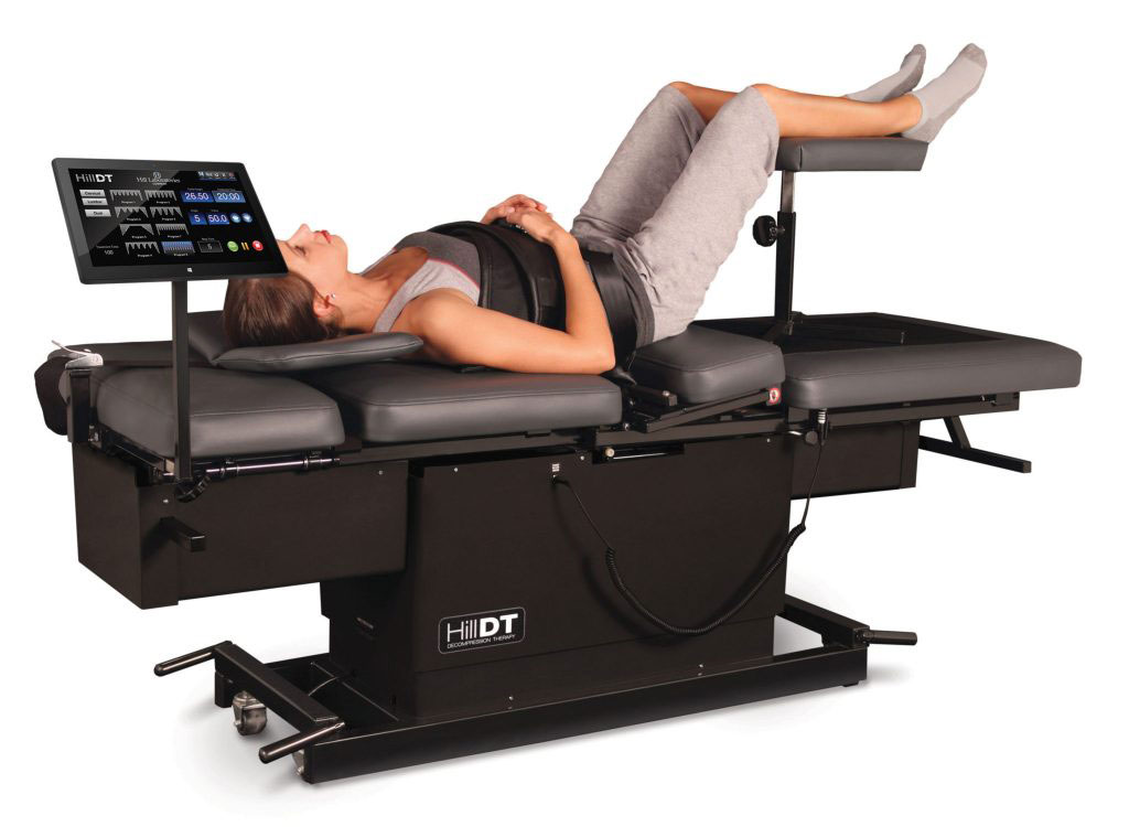 A person reclining on a modern, motorized massage table with digital controls and adjustable features.