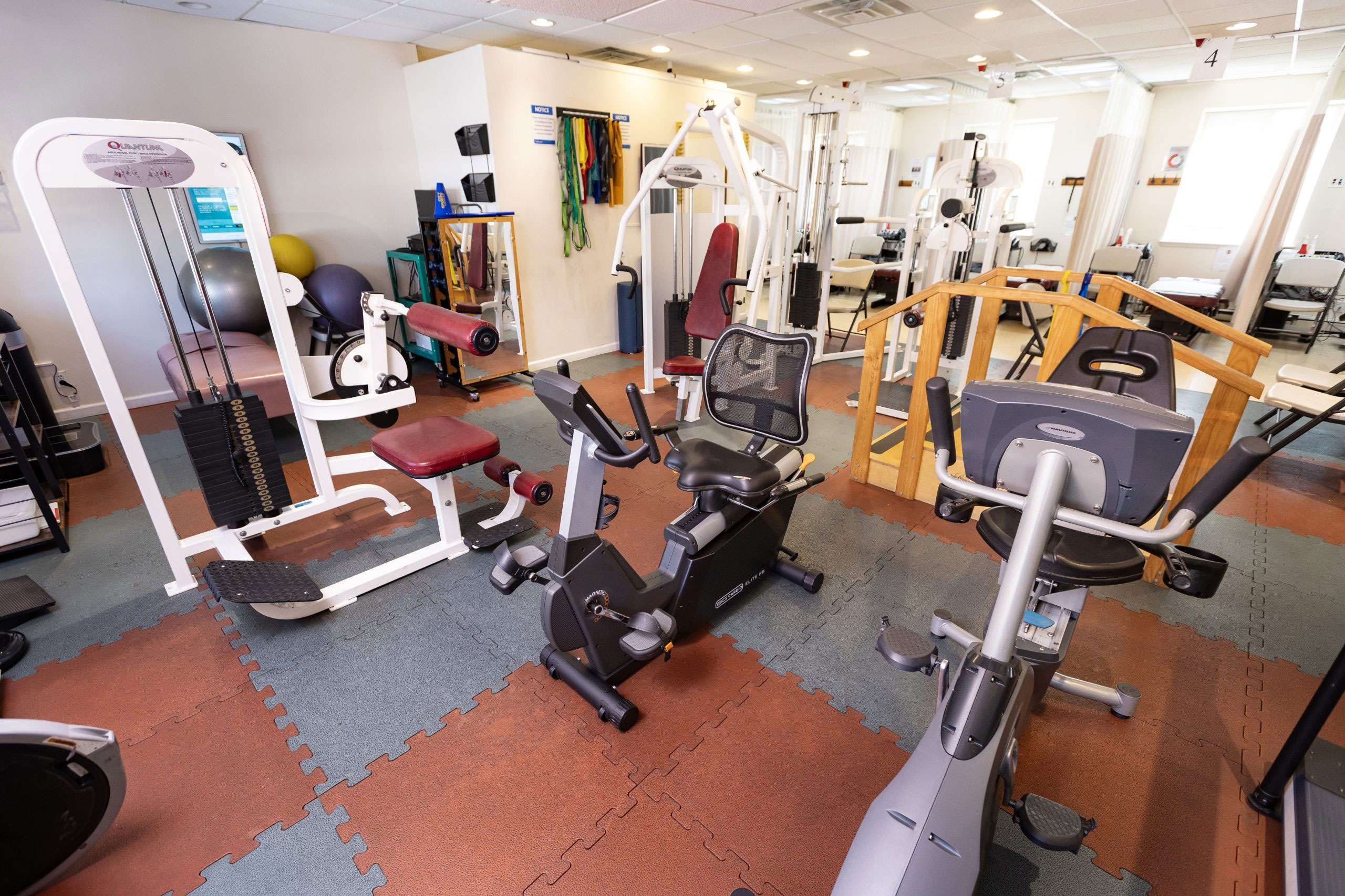 An image of a well-equipped gym with various exercise machines and weights.