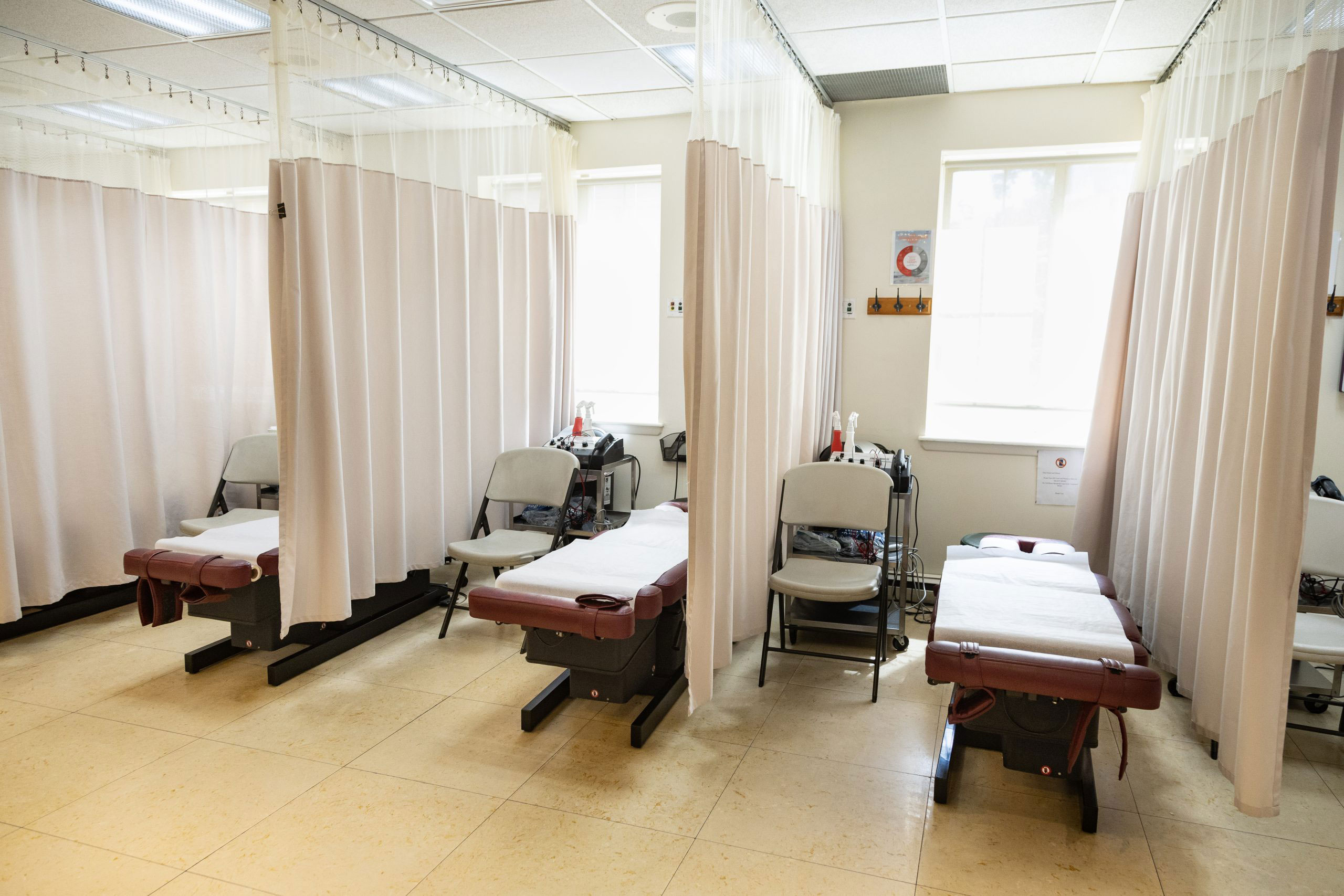 The image shows an interior space, specifically a room with multiple beds and curtains, which appears to be a medical or dental examination area.