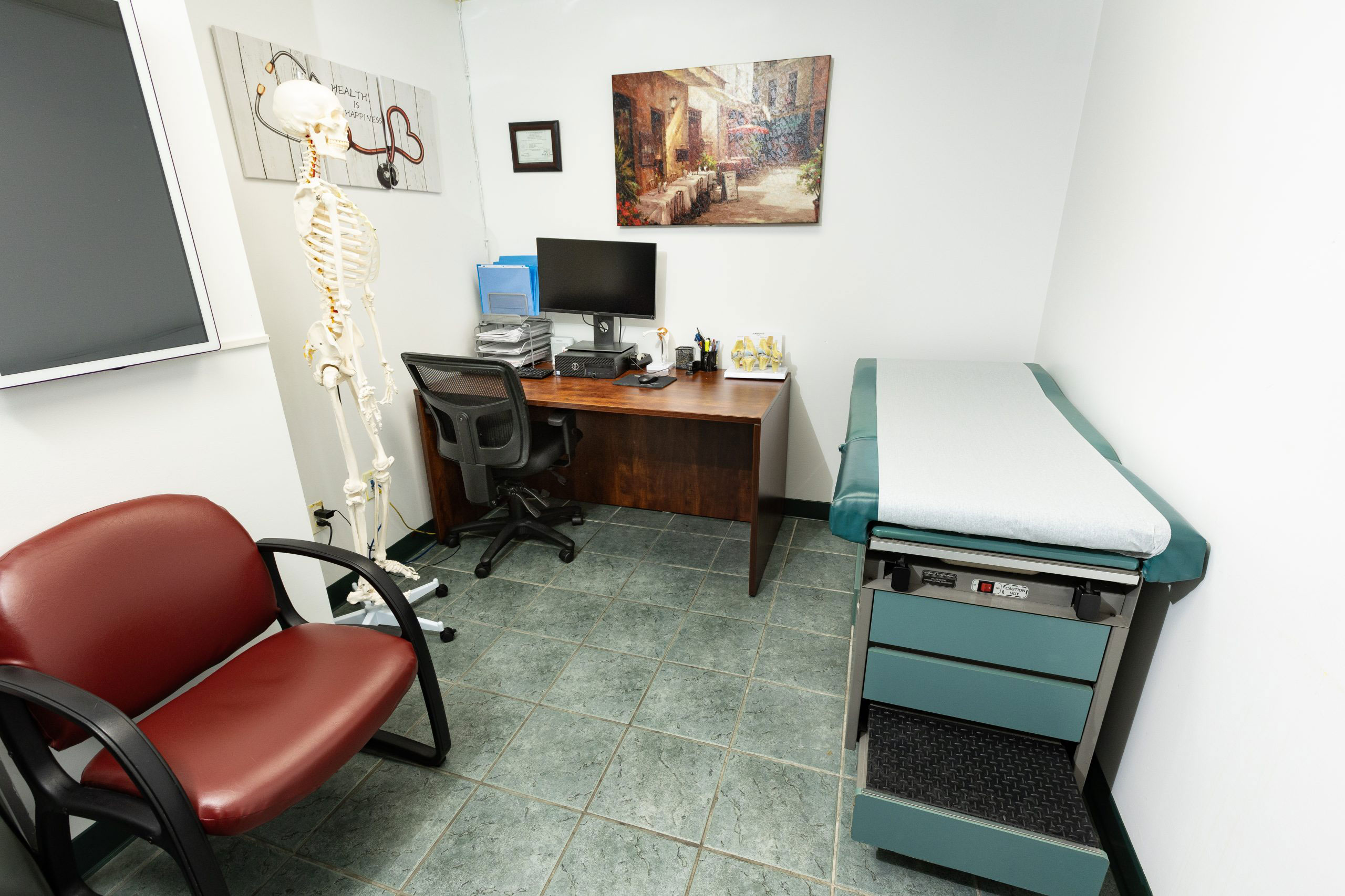 The image depicts an interior space that appears to be a medical examination room, equipped with a desk, chair, and various medical equipment.