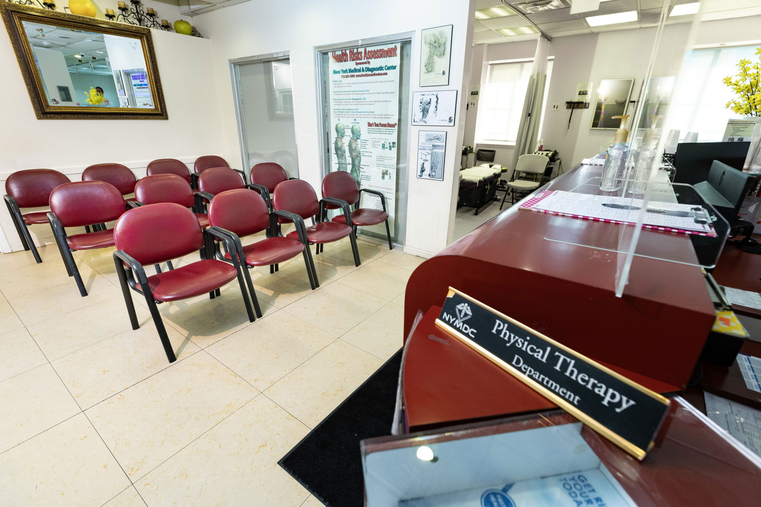 The image shows an interior view of a waiting area in a medical or dental office. It includes chairs, a reception desk with a sign that reads 'Physiotherapy Department,' and a wall-mounted plaque with the name 'Physiotherapy.